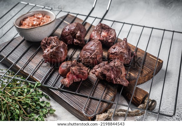 BBQ Grilled lamb mutton kidney, offal meat on\
grill. White background. Top\
view.
