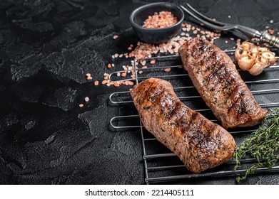 BBQ grilled Lamb tenderloin fillet meat on grill, mutton loin steak. Black background. Top view. Copy space. - Shutterstock ID 2214405111