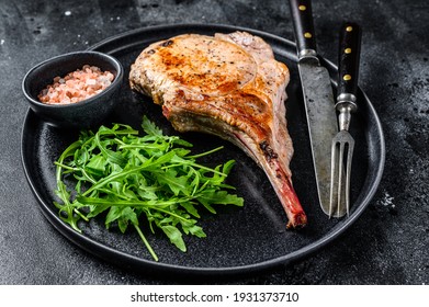 BBQ Grilled Tomahawk Pork Chop Meat Steak On A Marble Board. Black Background. Top View.