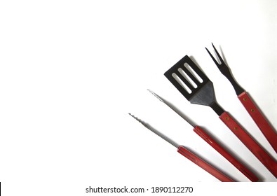 BBQ Instruments Kit - Tongs, Spatula, Fork - Close Up Isolated On White Background Flat Lay. Image Contains Copy Space