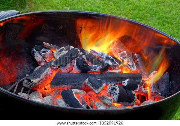 ピットに輝く熱い炭を入れたbbqケトルグリル 料理のコンセプト 裏庭の芝生に食べ物を用意するため 燃える石炭を備えた屋外のバーベキューグリル の写真素材 今すぐ編集