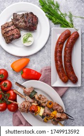 BBQ Mix Of Grilled Game Meat, Steaks, Cheese Sausages With Sour Cream Dip And Vegetables 