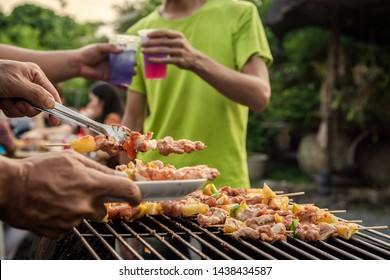 BBQ Party Group Of People At Barbecue Dinner Friends Having Food Together Outdoor As Summer With Friendship Asian Person.