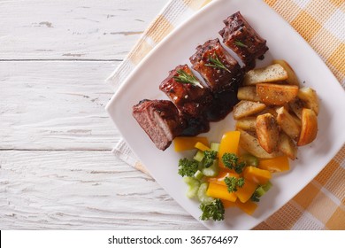 BBQ Pork Ribs With A Side Dish Of Vegetables On A Plate. Horizontal View From Above
