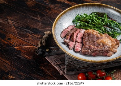 BBQ Roasted Chuck Roll Tender beef steak with salad in plate. Wooden background. Top view. Copy space.