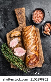 BBQ Roasted Pork Tenderloin Fillet Meat On Wooden Board With Herbs. Black Background. Top View