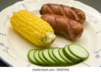 BBQ Sausages Or Hot Dogs With Cob Of Corn And Cucumber Salad