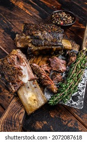 BBQ Short Chuck Beef Ribs With Herbs And Meat Cleaver. Dark Wooden Background. Top View