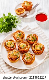 BBQ Sloppy Joe Muffins, Hamburger Bun Cups With Ground Beef And Onions Tossed In Sloppy Joe Sauce And Topped With Cheese On White Plate On Wood Table, Vertical View From Above