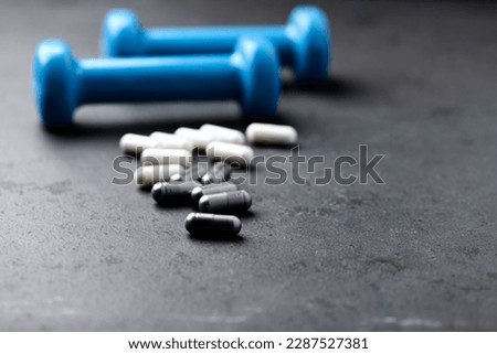 BCAA and creatie capsules. Bodybuilding food supplements on dark stone background. Soft focus. Close up. Copy space. 