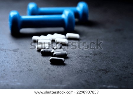 BCAA and creatie capsules. Bodybuilding food supplements on dark stone background. Soft focus. Close up. Copy space.                                