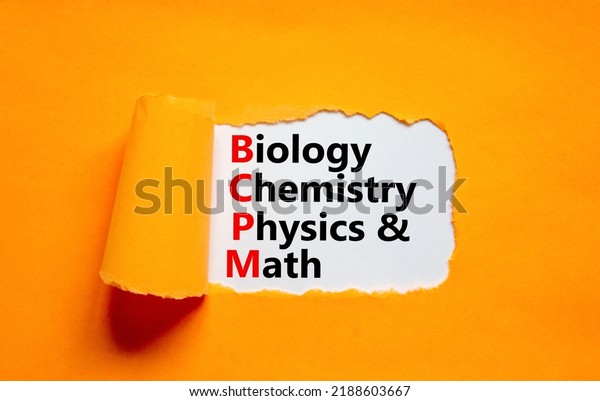 BCPM biology chemistry physics math symbol.\
Concept words BCPM biology chemistry physics math on white paper on\
beautiful orange background. Business BCPM biology chemistry\
physics math concept.