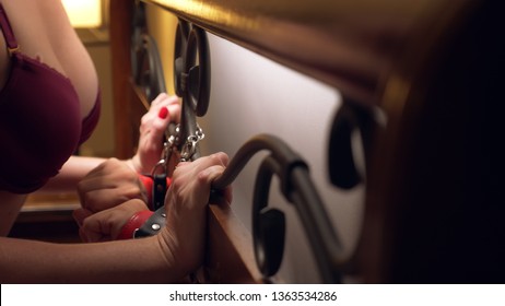 BDSM, Sex Toys. Romantic Couple In Bed. The Hands Are Handcuffed To The Wrought Headboard. Close-up, Details