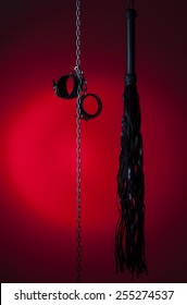 bdsm toys hanging on a red background