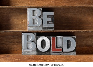 be bold phrase made from metallic letterpress type on wooden tray 