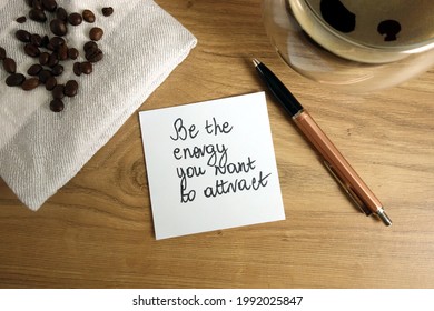 Be the energy you want to attract text handwritten on sticky note with coffee and pen, law of attraction concept