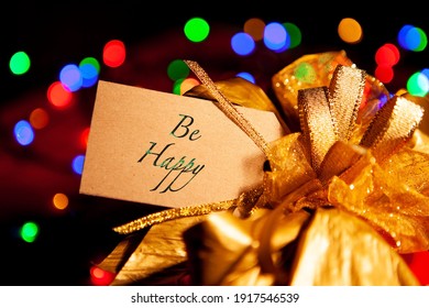 Be Happy - Text On A Gift Box Label With A Large Gold Bow. 