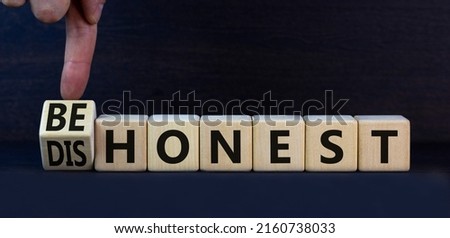 Be honest or dishonest symbol. Turned cube and changed concept words Dishonest to Be honest. Beautiful grey table grey background. Business and be honest or dishonest concept. Copy space.
