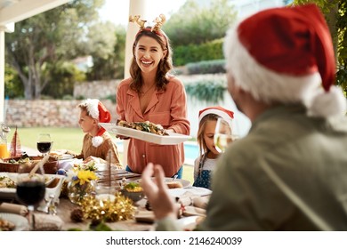 Be Jolly And Fill Your Belly. Cropped Shot Of A Happy Family Having Christmas Lunch Together.