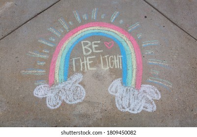 Be The Light Written With Sidewalk Chalk With A Rainbow