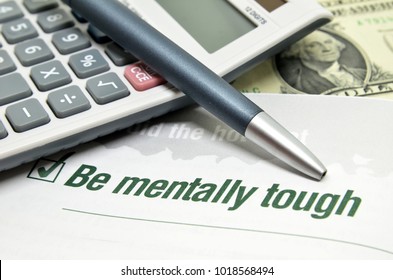 Be Mentally Tough Printed On Book With Calculator And Pen