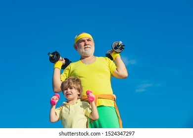 Be In Motion. Body Care And Healthcare. Grandfather And Child Lifting Weights. Senior Man And Child In Family Health Club. Father And Children Having Workout