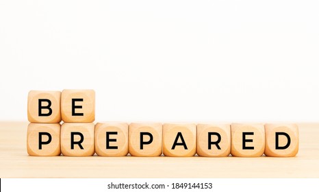 Be prepared phrase in wooden blocks on table. White background. Copy space