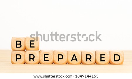 Be prepared phrase in wooden blocks on table. White background. Copy space