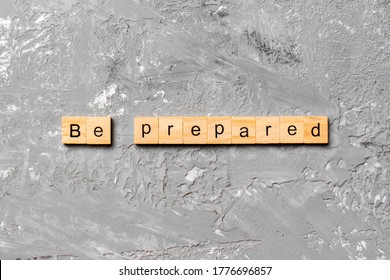 BE PREPARED word written on wood block. BE PREPARED text on cement table for your desing, concept.