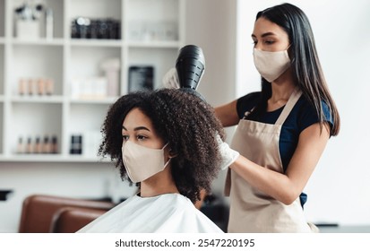 Be safe and beautiful. Hairdresser and customer wearing protective masks at beauty salon, close up - Powered by Shutterstock