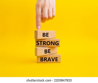 Be Strong Be Brave Symbol. Concept Words Be Strong Be Brave On Wooden Blocks. Beautiful Yellow Background. Businessman Hand. Business Concept. Copy Space.