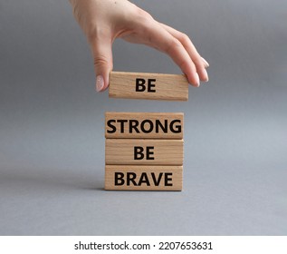 Be Strong Be Brave Symbol. Concept Words Be Strong Be Brave On Wooden Blocks. Beautiful Grey Background. Businessman Hand. Business Concept. Copy Space.