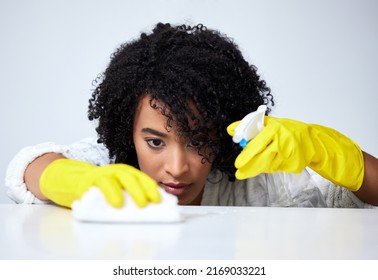 Be Thorough When Cleaning. Shot Of A Young Woman Spraying Down A Counter To Clean It.