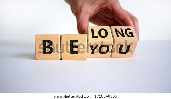 Be you,\
belong symbol. Businessman hand turns cubes and changes words \'be\
you\' to \'belong\'. Beautiful white background. Business, belonging\
and be you, belong concept. Copy\
space.