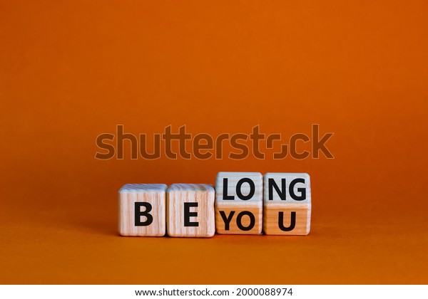 Be you, belong symbol.
Turned cubes and changed words 'be you' to 'belong'. Beautiful
orange background. Business, belonging and be you, belong concept.
Copy space.