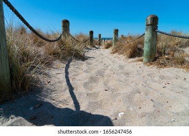 Beach access between rope and bollards across sand path at main beach Mount Maunganui, New Zealand.