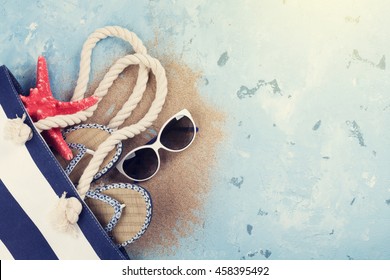 Beach Accessories. Bag, Sunglasses And Flip-flops On Stone Background. Top View With Copy Space. Sunny Toned