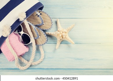 Beach Accessories. Bag, Towel, Sunglasses And Flip-flops On Wooden Background. Top View With Copy Space. Sunny Toned