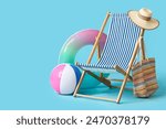 Beach accessories with deckchair, inflatable ring and ball on blue background