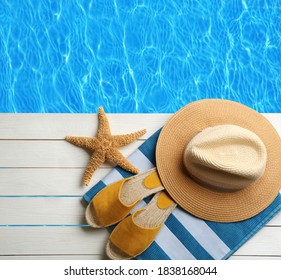 Beach Accessories On White Wooden Deck Near Swimming Pool, Flat Lay 