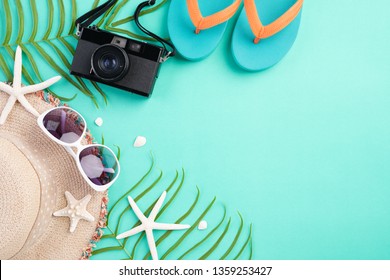 Beach Accessories Retro Film Camera, Sunglasses, Flip Flop, Starfish Beach Hat And Sea Shell On Bright Pastel Green Background For Summer Holiday And Vacation Concept.