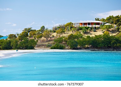 Beach In Antigua With Blue Sky And Turquoise Water, A Beach Bar In The Background.