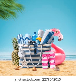 Beach bag with accessories and cute inflatable flamingo on a tropical beach, summer vacations and travel concept
