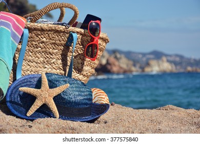 Beach bag with a book and a telephone and sunglasses accompanied by a sea star - Powered by Shutterstock