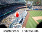 Beach ball floating above the crowd at a stadium of a baseball game