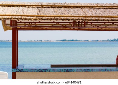 Beach Bar With Straw Flat With Sea On The Background.