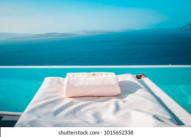 beach bed chair with towel looking out over the caldera by the swimming pool , Santorini Oia, infinity swimming pool looking at the sea
