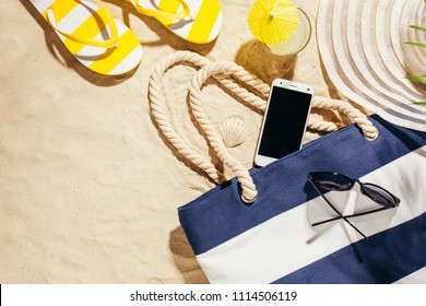 Beach Blue Bag, Flip Flops And Cell Phone On A Tropical Beach. Top View With Copy Space.