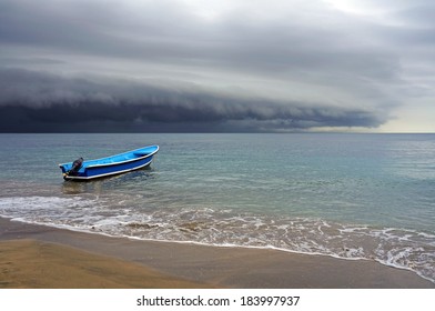 Beach with a boat and storm with threatening clouds coming from the Caribbean sea, Costa Rica