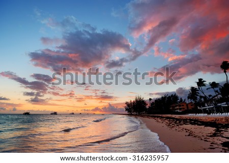 Beach, boats and hotel, at sunset